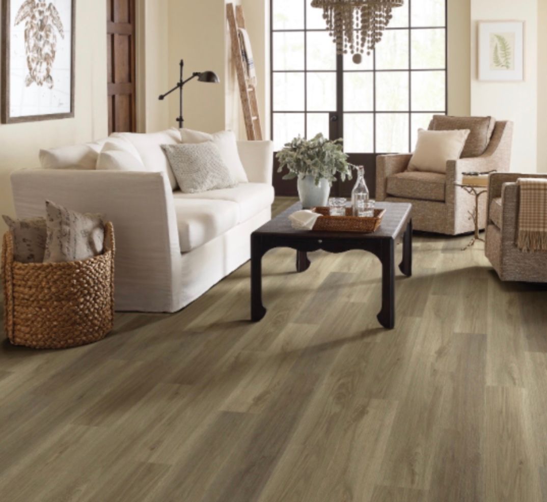 Living room with white sofa, armchairs, wood flooring, and a dark coffee table.