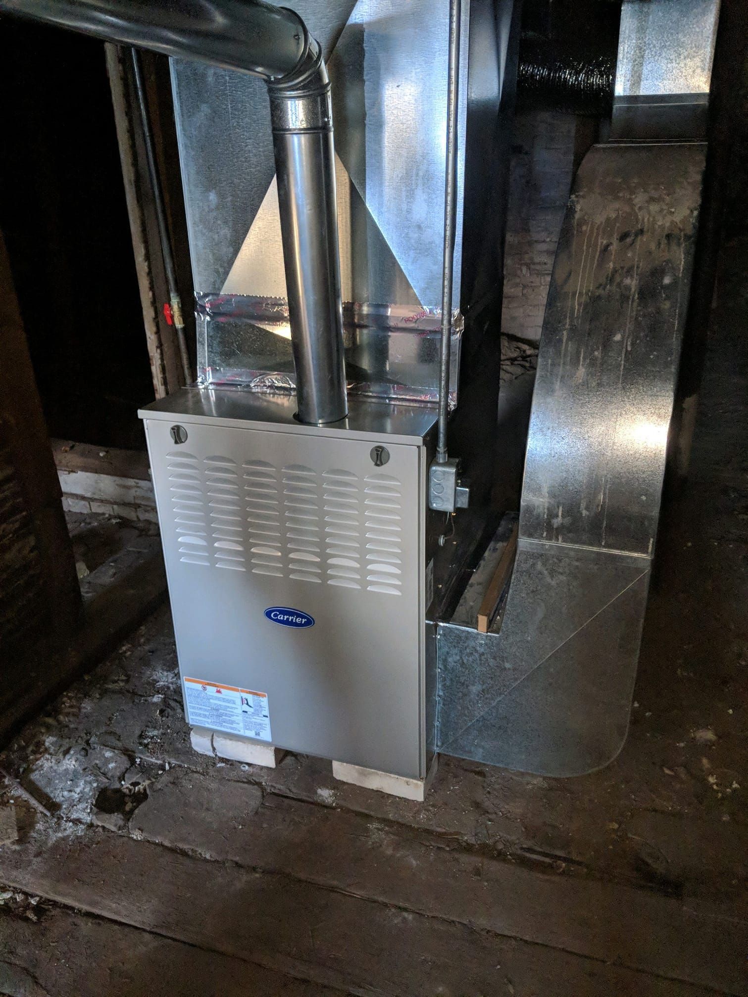 A gas furnace is sitting in the attic of a house.