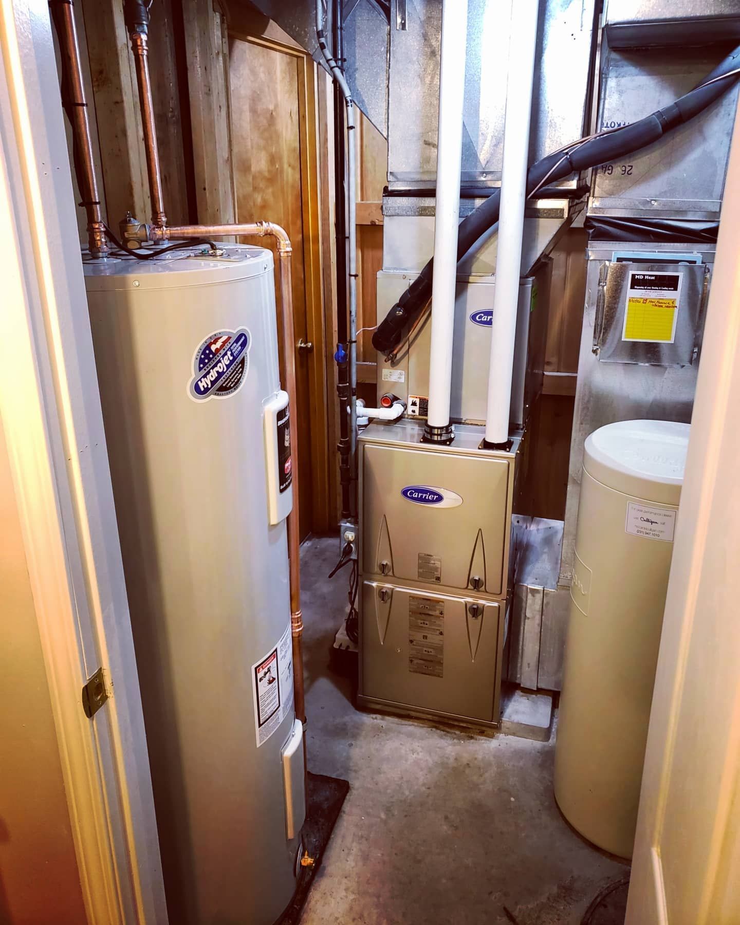 A room with a water heater and a furnace in it.