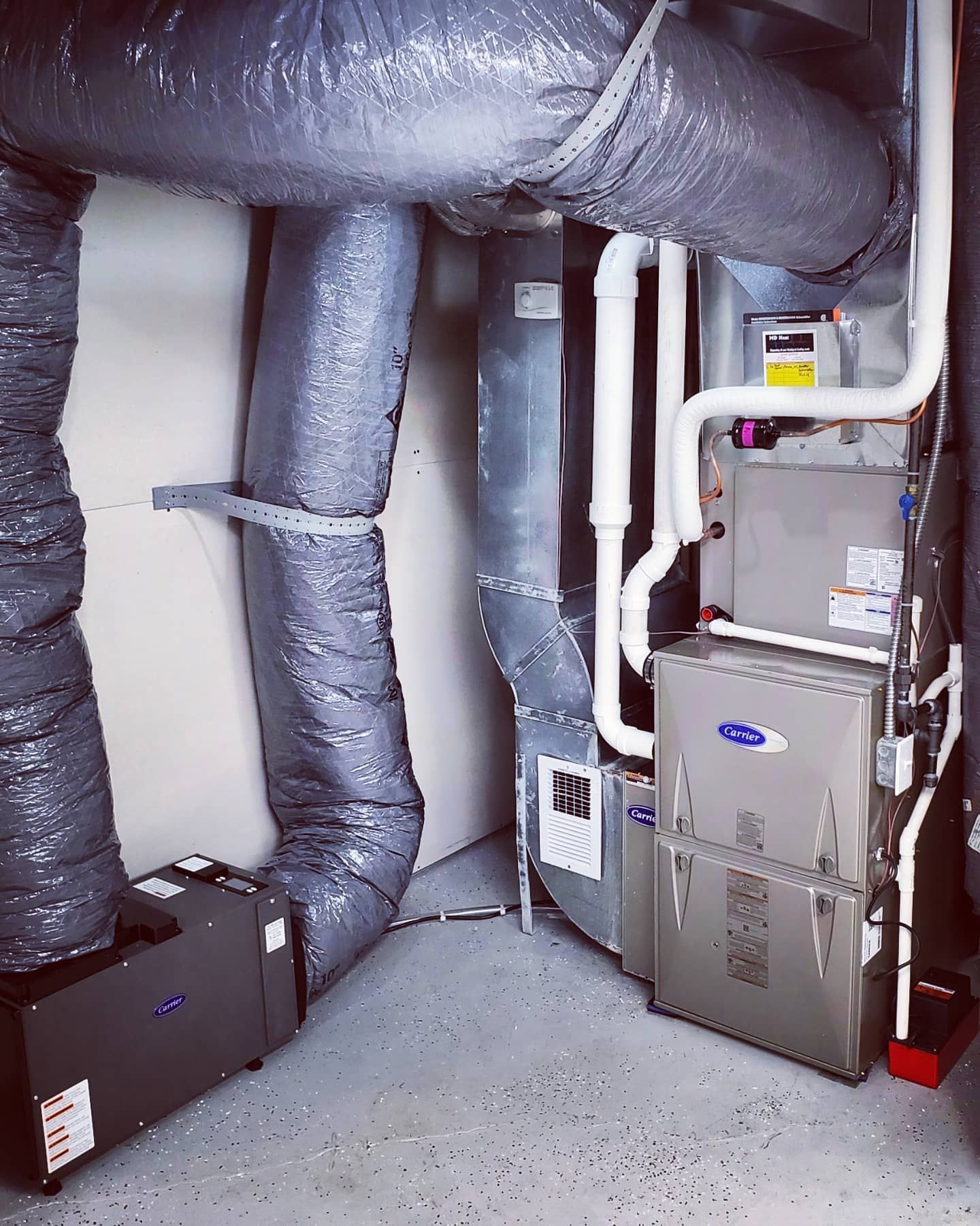 A room with a lot of pipes and a furnace.