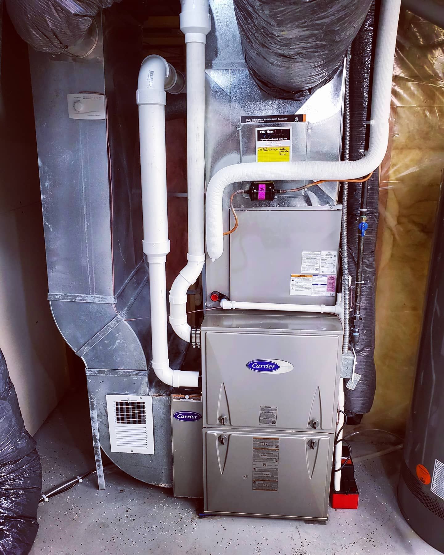 A stainless steel air conditioner is sitting in a basement.