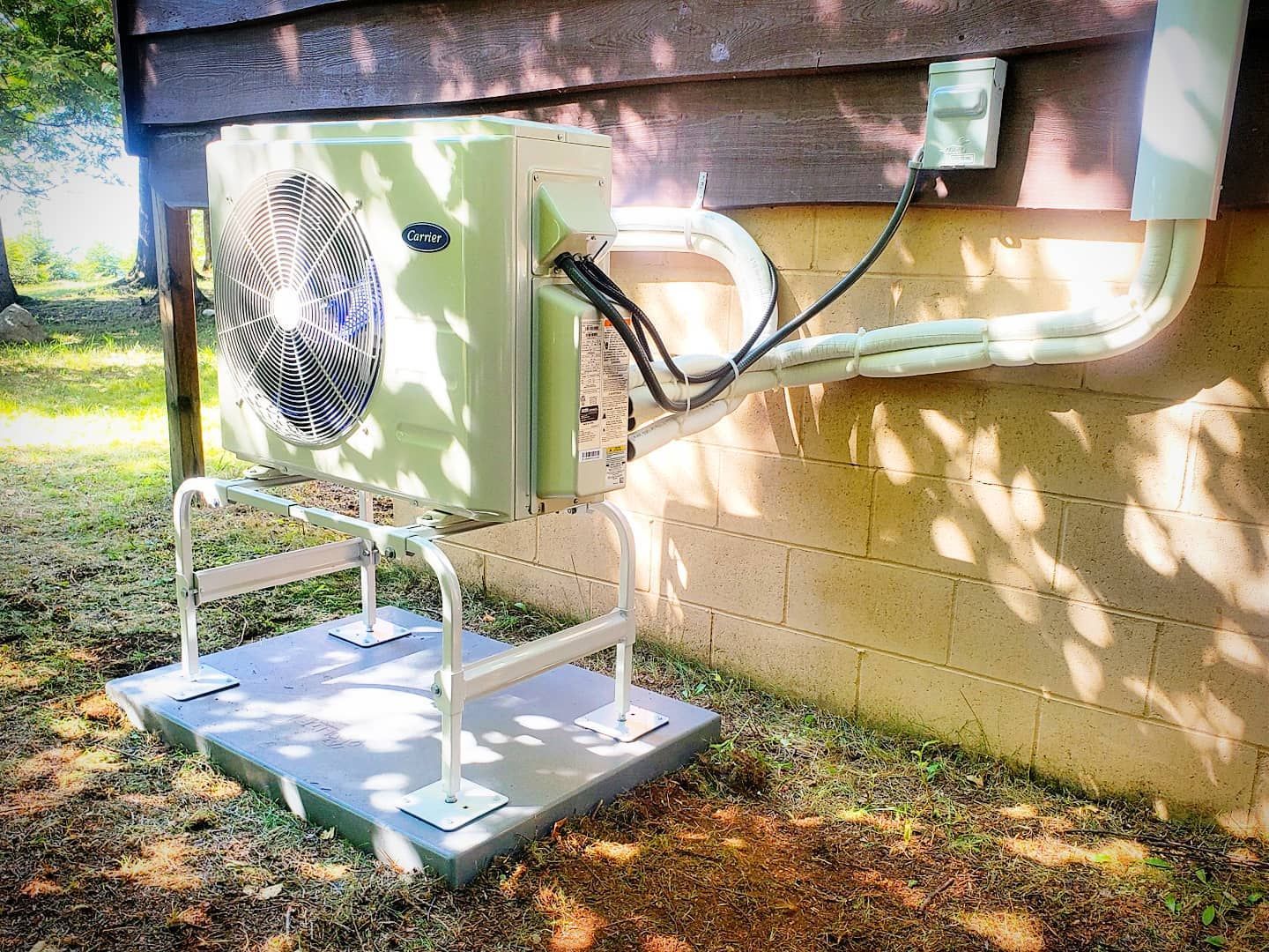 A green air conditioner is mounted on the side of a building.