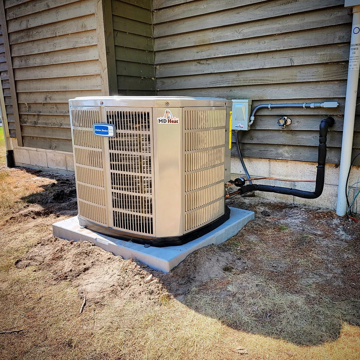 A large air conditioner is sitting on the side of a house.