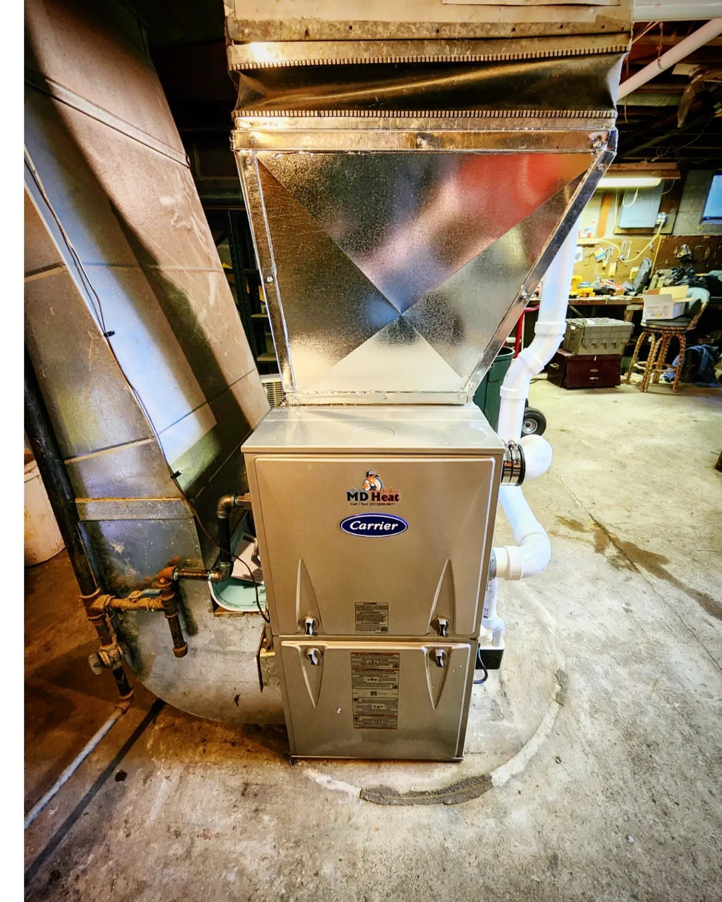 A stainless steel air conditioner is sitting in a basement.