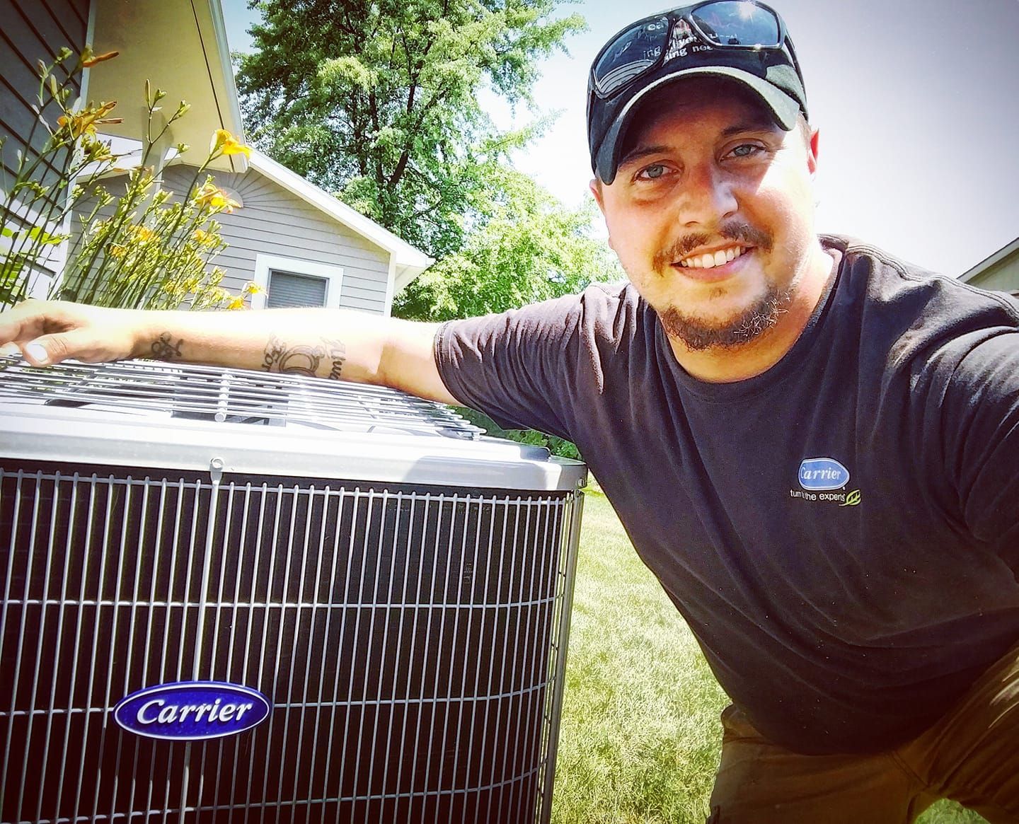 A man is standing in front of a carrier air conditioner.
