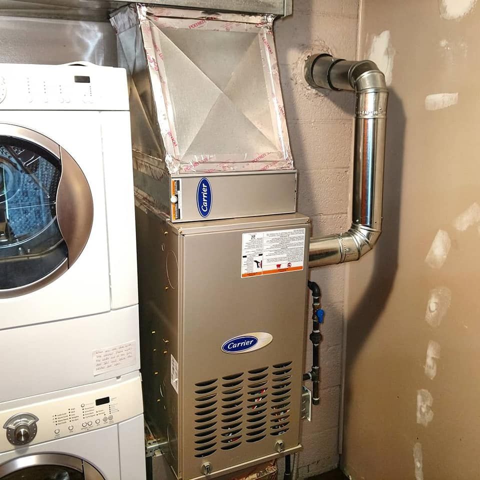 A washer and dryer are stacked next to a carrier air conditioner