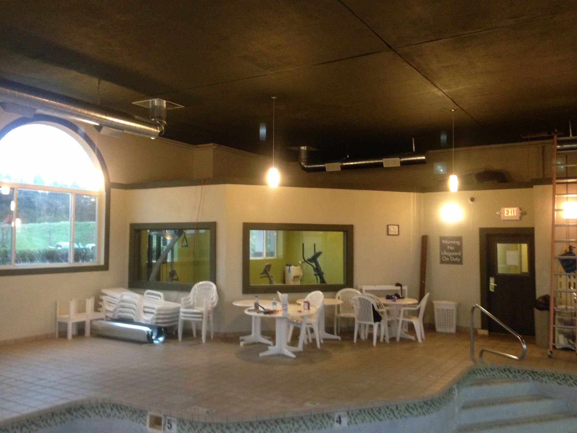 An indoor swimming pool with tables and chairs around it