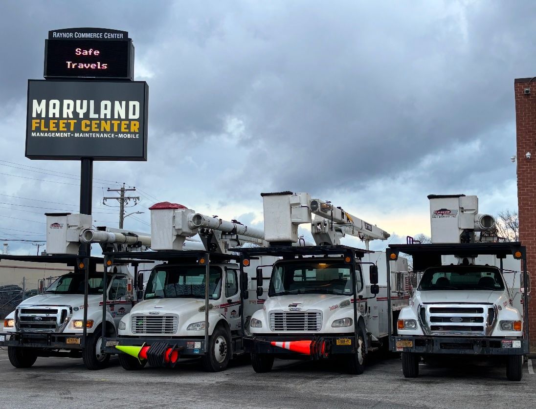 A row of trucks parked in front of a maryland fleet center sign