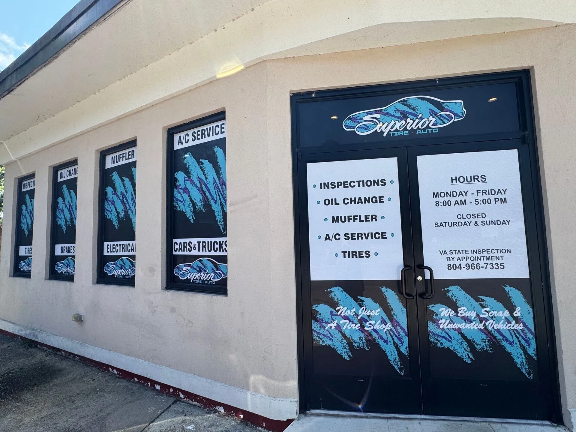 Exterior of Superior auto shop with black and teal signage.