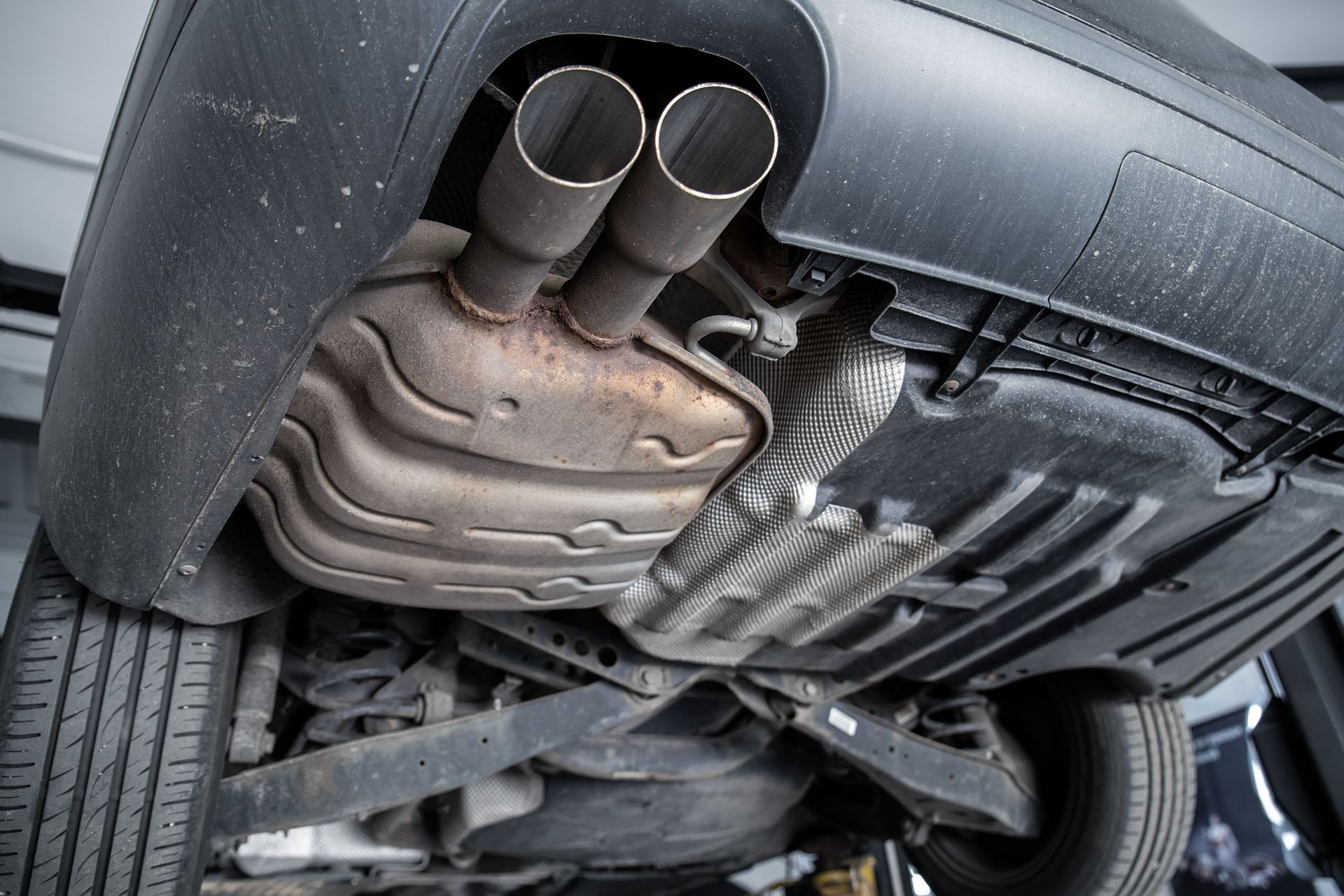 Underside of a car showing the exhaust system with two pipes and a muffler.