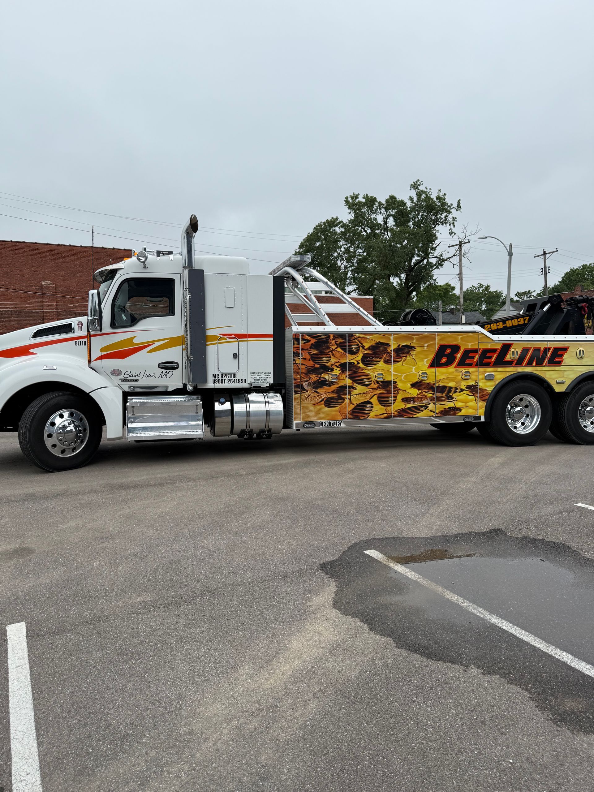 A large tow truck is parked in a parking lot.