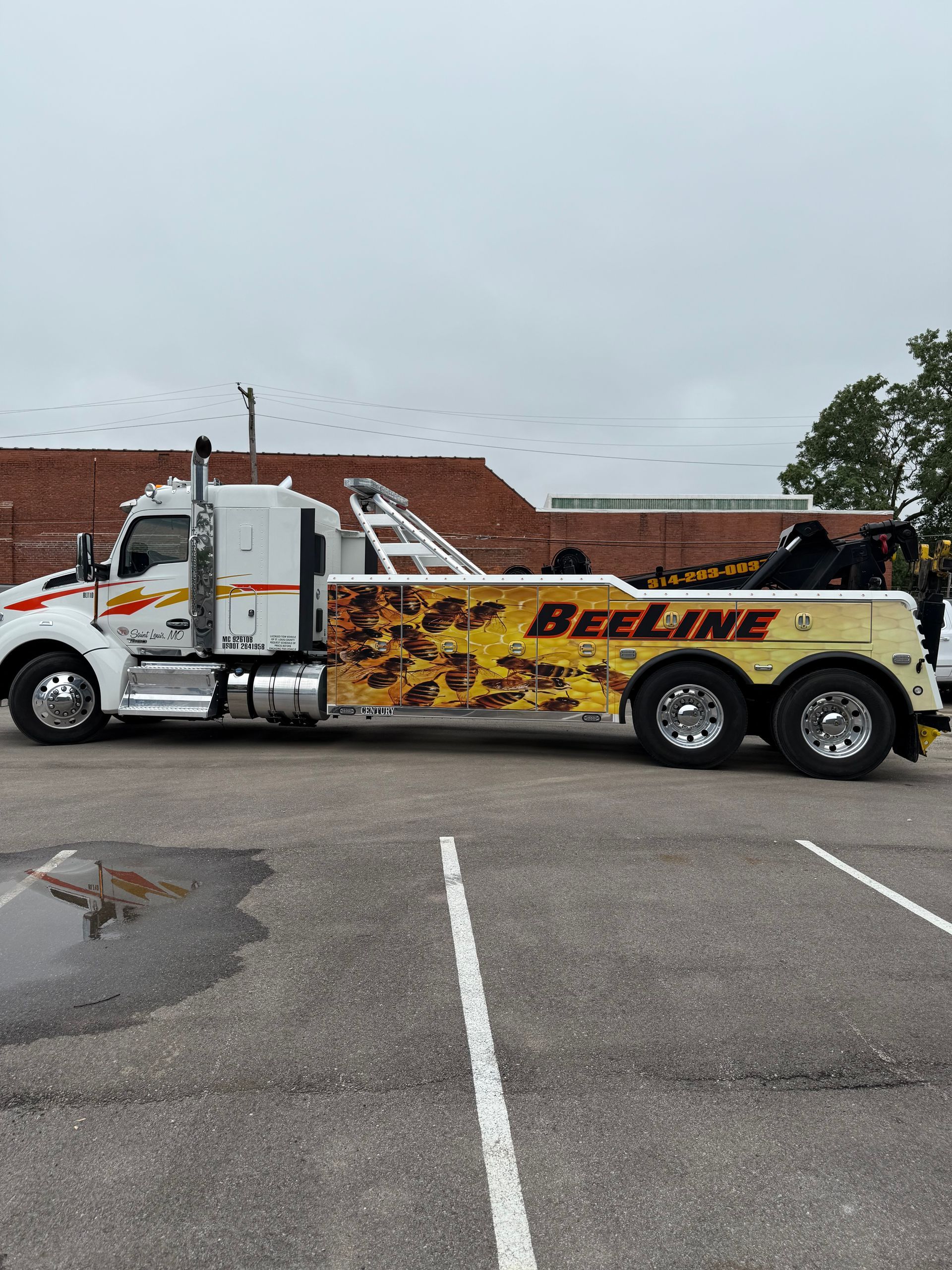 A white tow truck is parked in a parking lot.