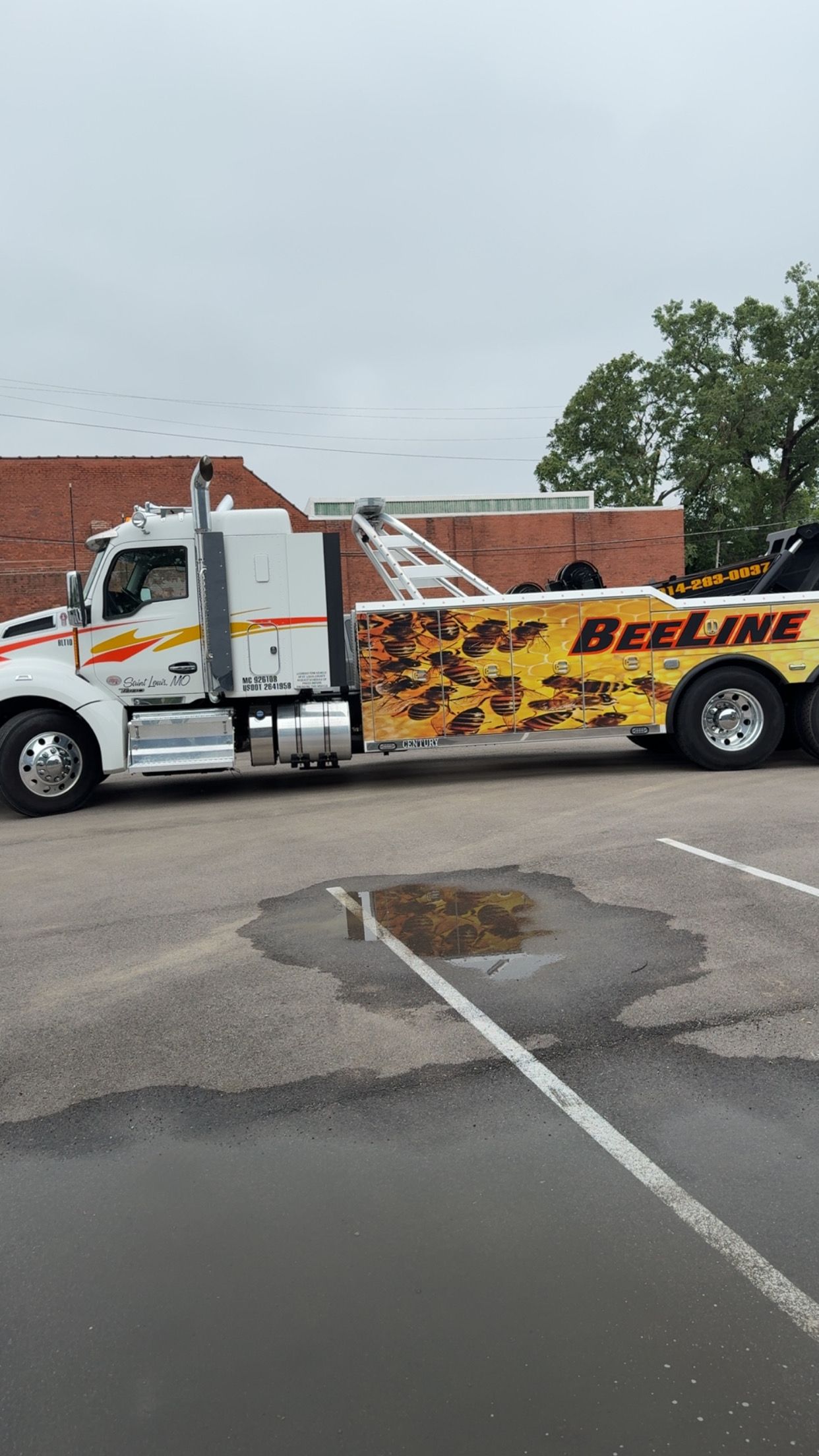 A large tow truck is parked in a parking lot.