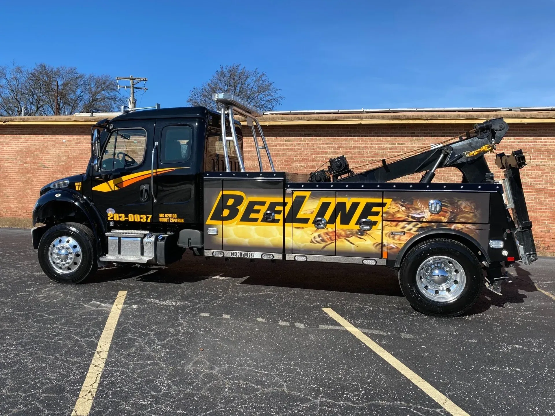 A beeline tow truck is parked in a parking lot.
