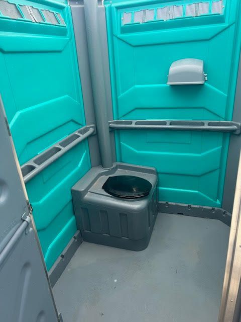 A green and gray portable toilet with a black seat