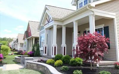 An aerial view of a house with a lot of grass and trees in the background.