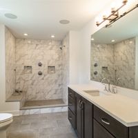 A bathroom with a toilet , sink , and shower.