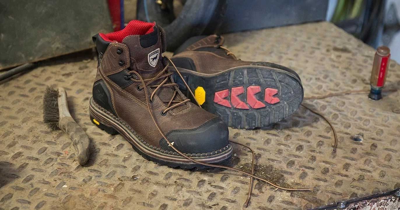 Brown work boots with red accents on a metal surface.