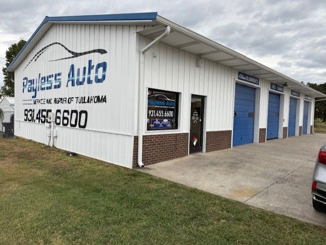A car is parked in front of a building that says payless auto