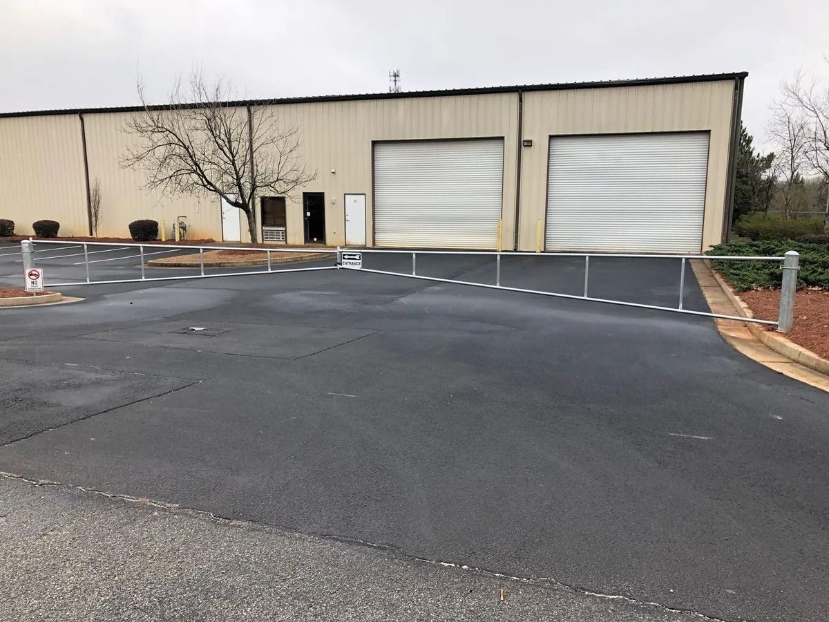 Industrial building with two overhead doors. A barrier prevents access to the building's entrance.