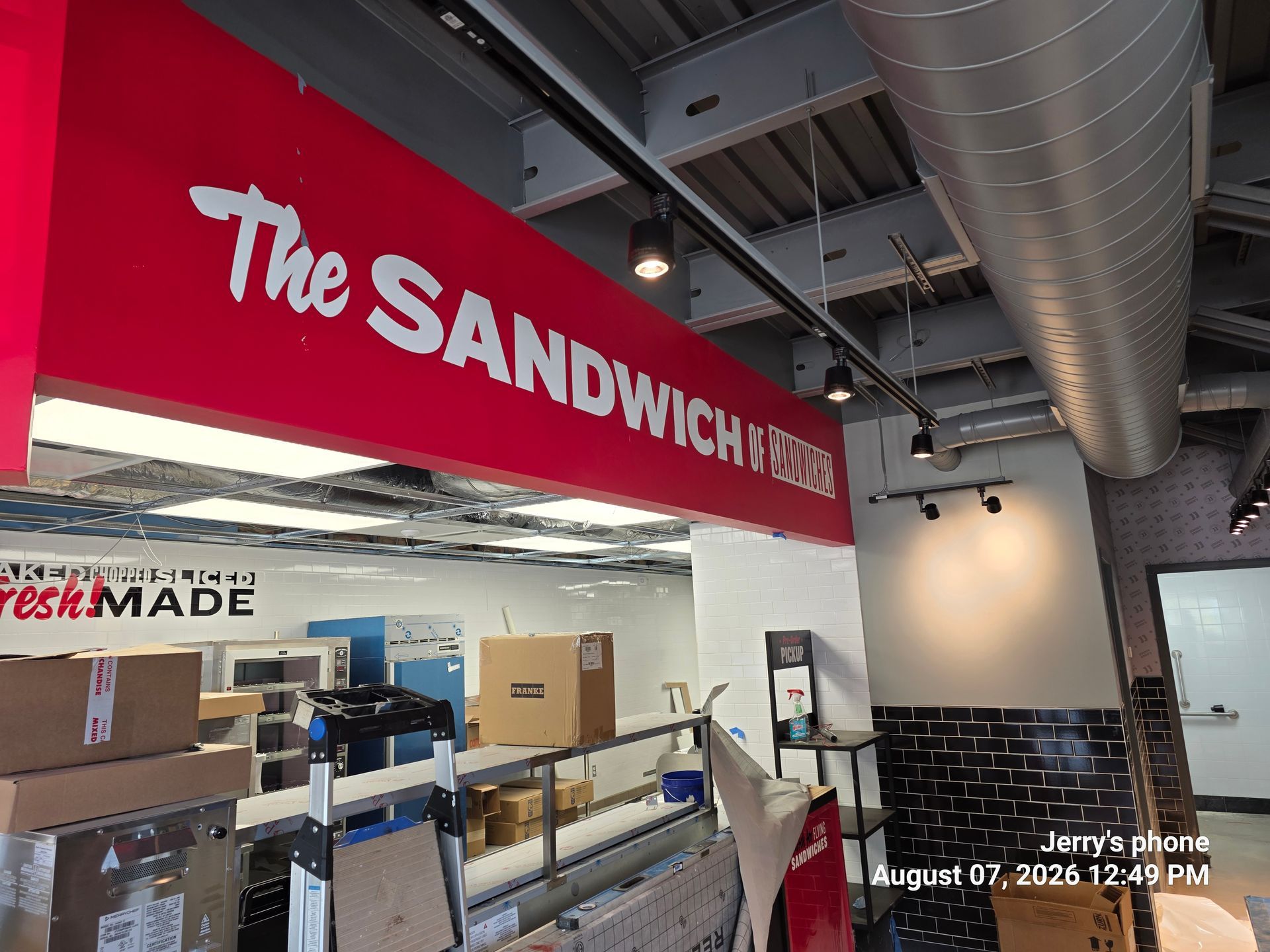 The Sandwiches storefront with red sign inside a modern indoor market.
