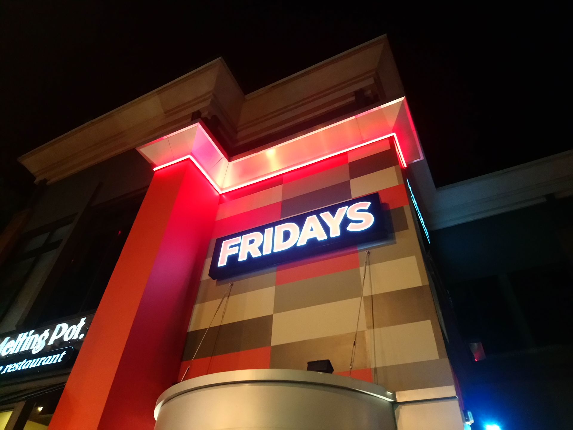 Illuminated TGI Fridays restaurant sign on a building at night