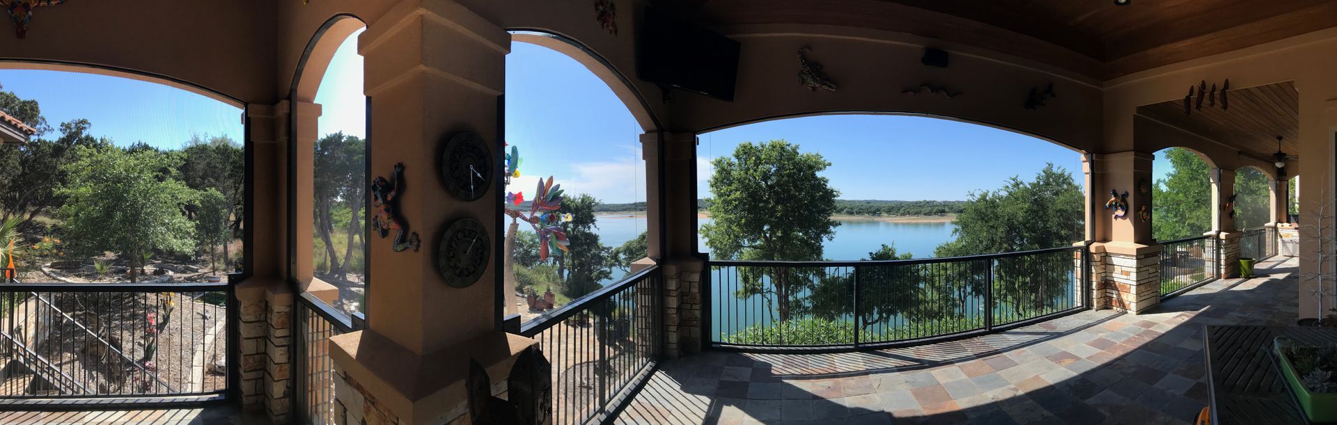 a large balcony with a view of a lake and trees .