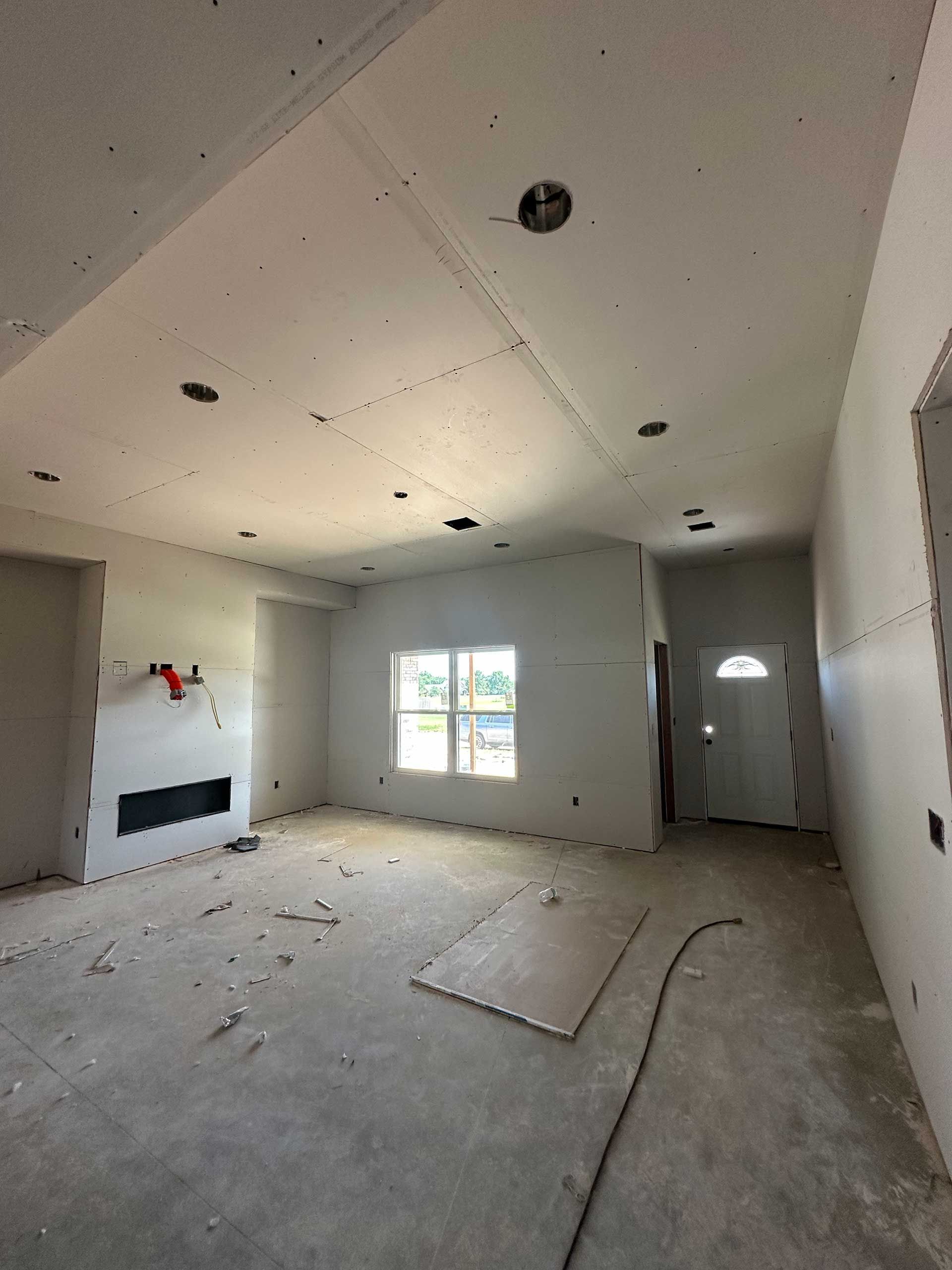 a living room with a fireplace and a door in a house under construction
