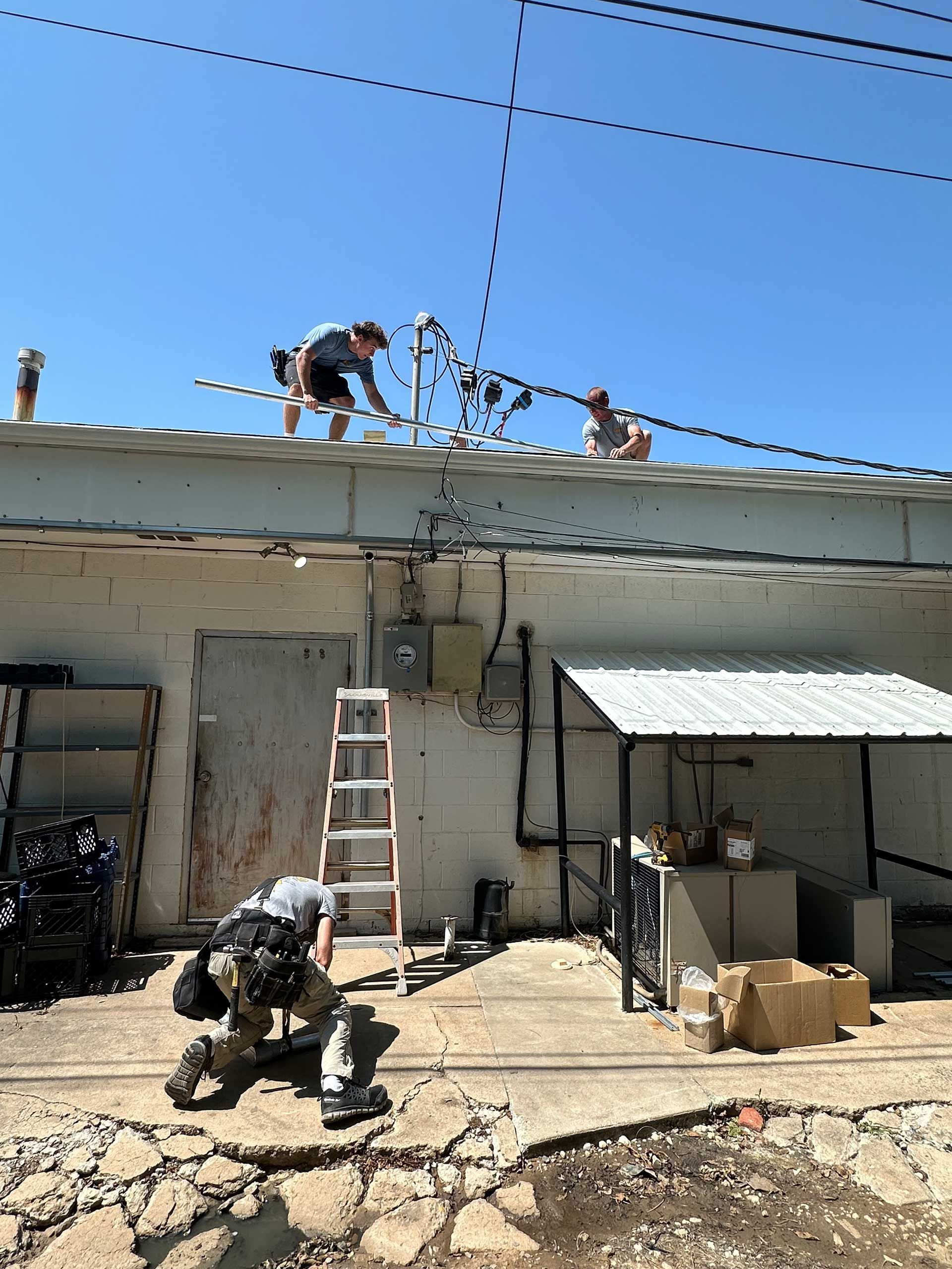 men are working on the roof of a building