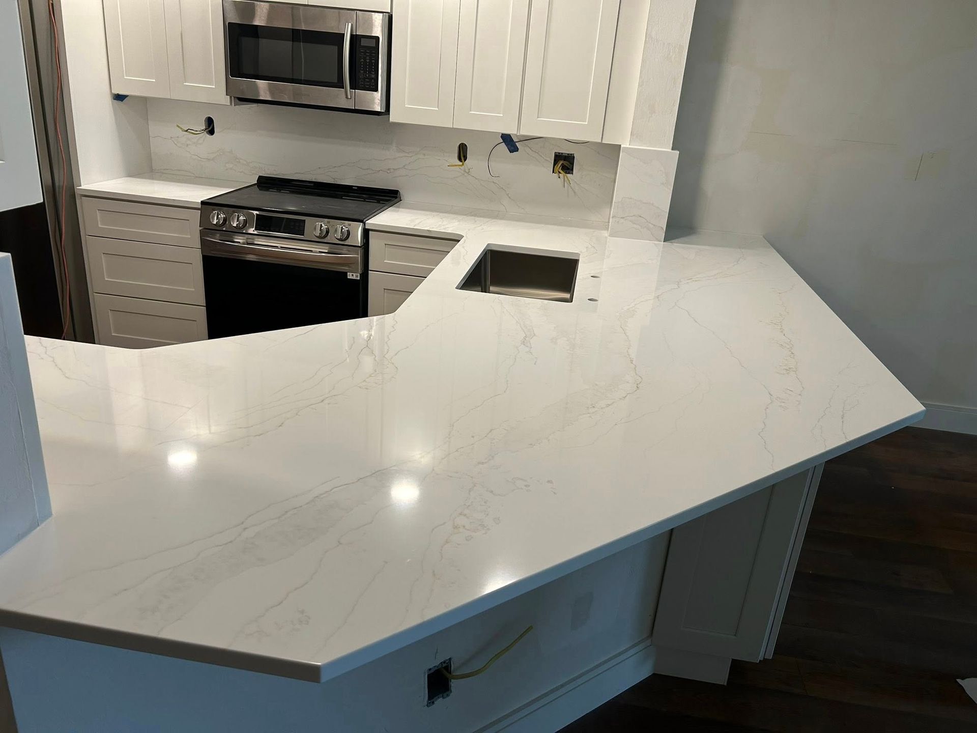 Kitchen with white cabinets, light countertop, and stainless steel appliances.
