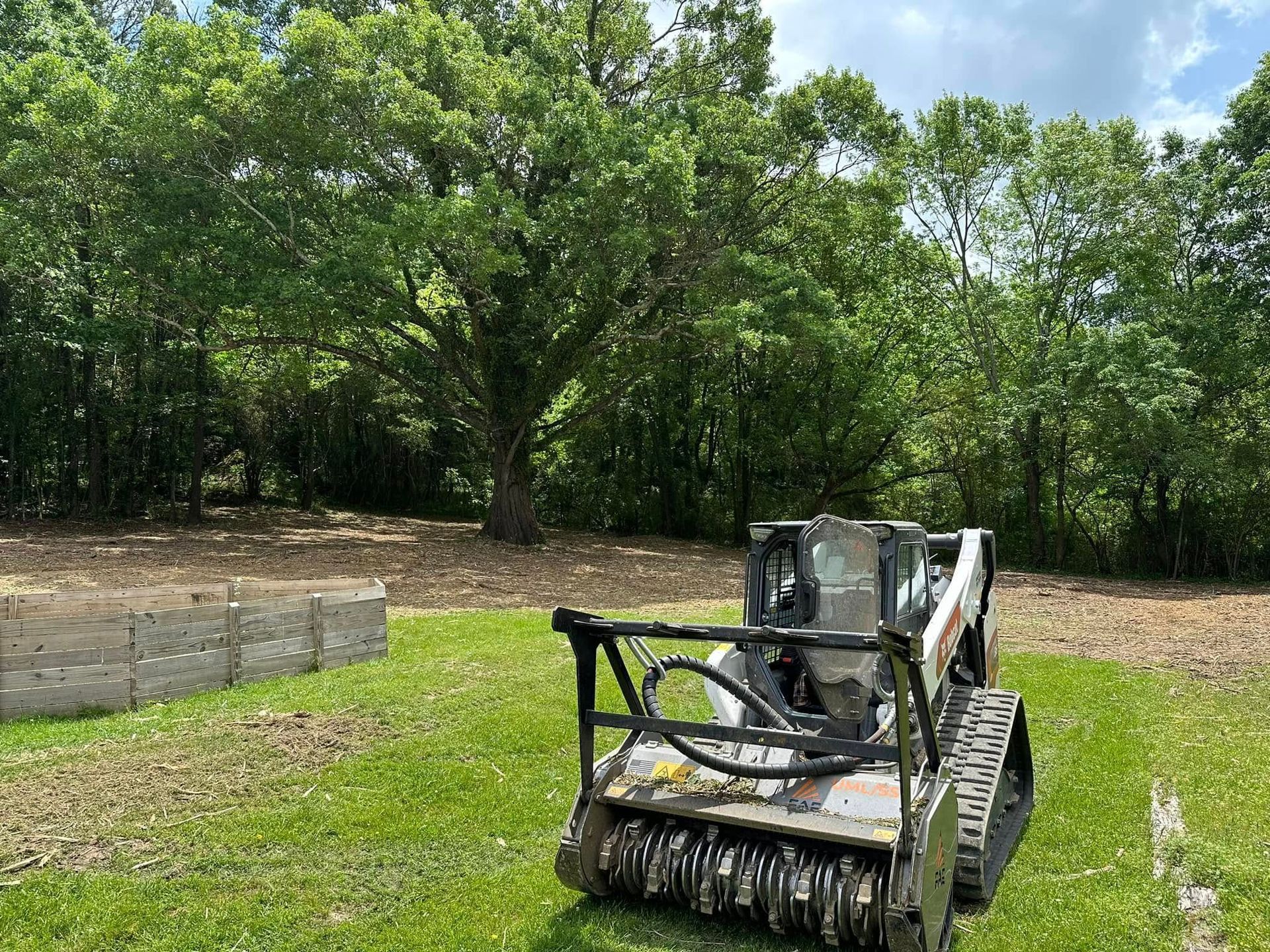 A bulldozer is sitting on top of a lush green field.