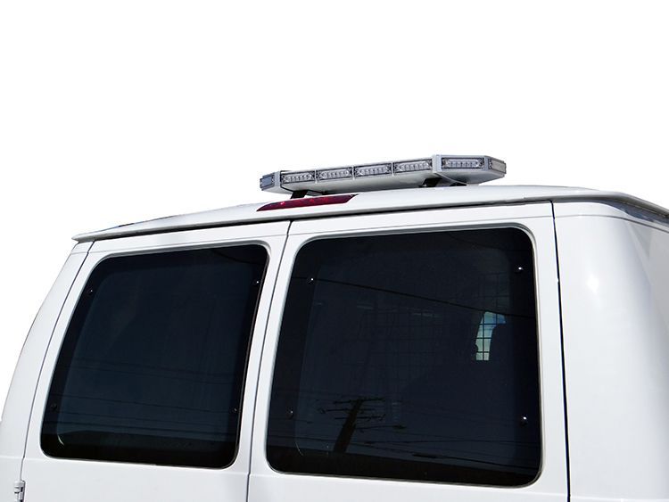 White van with tinted windows and emergency lights on top.