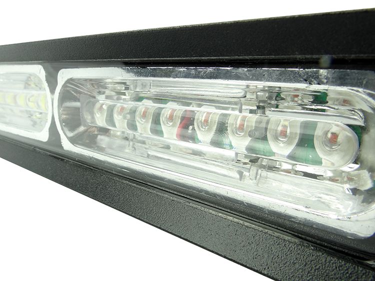 Close-up of a black LED emergency light bar with clear lenses and white and red lights.