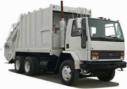 White garbage truck parked on a paved road.