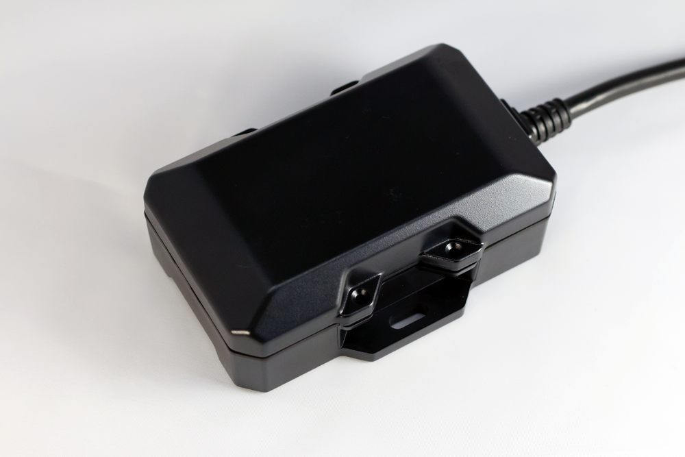 Black electronic device with a cable attached, likely for automotive diagnostics or data logging.