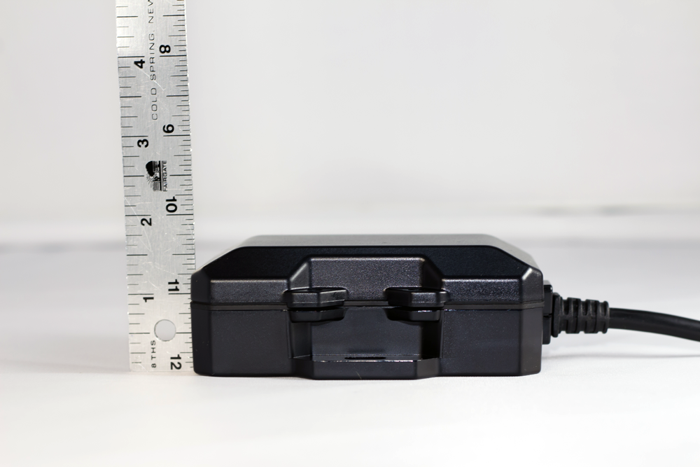 Black electronic device with a ruler, likely for size comparison.