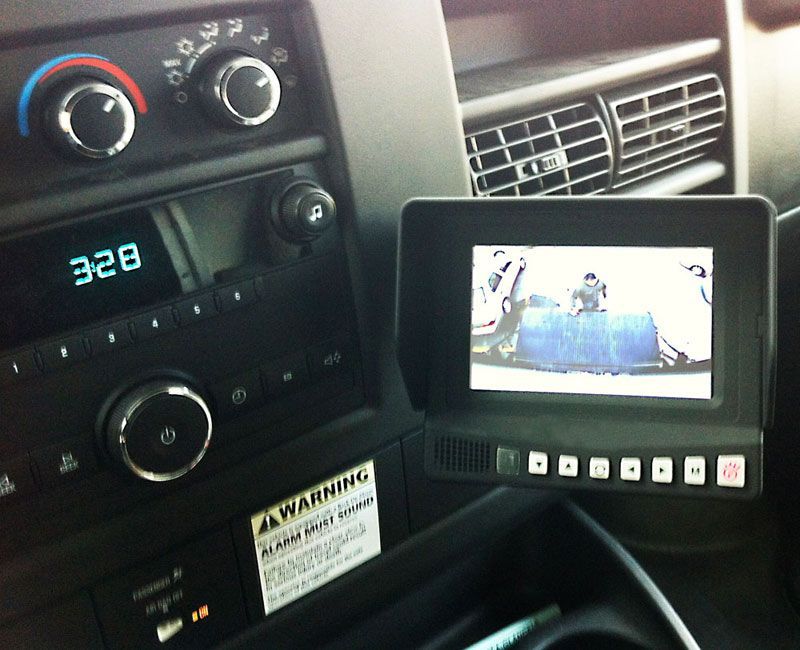 Dashboard with monitor showing a view from a rear camera. Digitals display 3:28. Black and gray interior.
