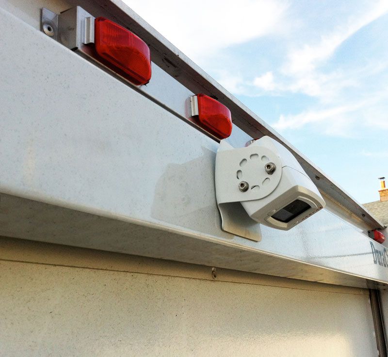 White trailer rear with red lights and a mounted white camera.