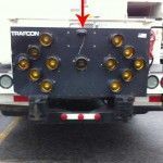 Arrow board displaying directional signals on the back of a truck, red arrow pointing at the top.