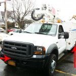 White utility truck with a raised aerial, parked on a street; red arrows point to bumper and side compartment.