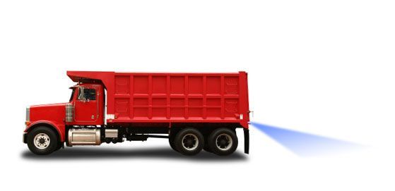 White semi-truck with black dumpster lifted in the air.