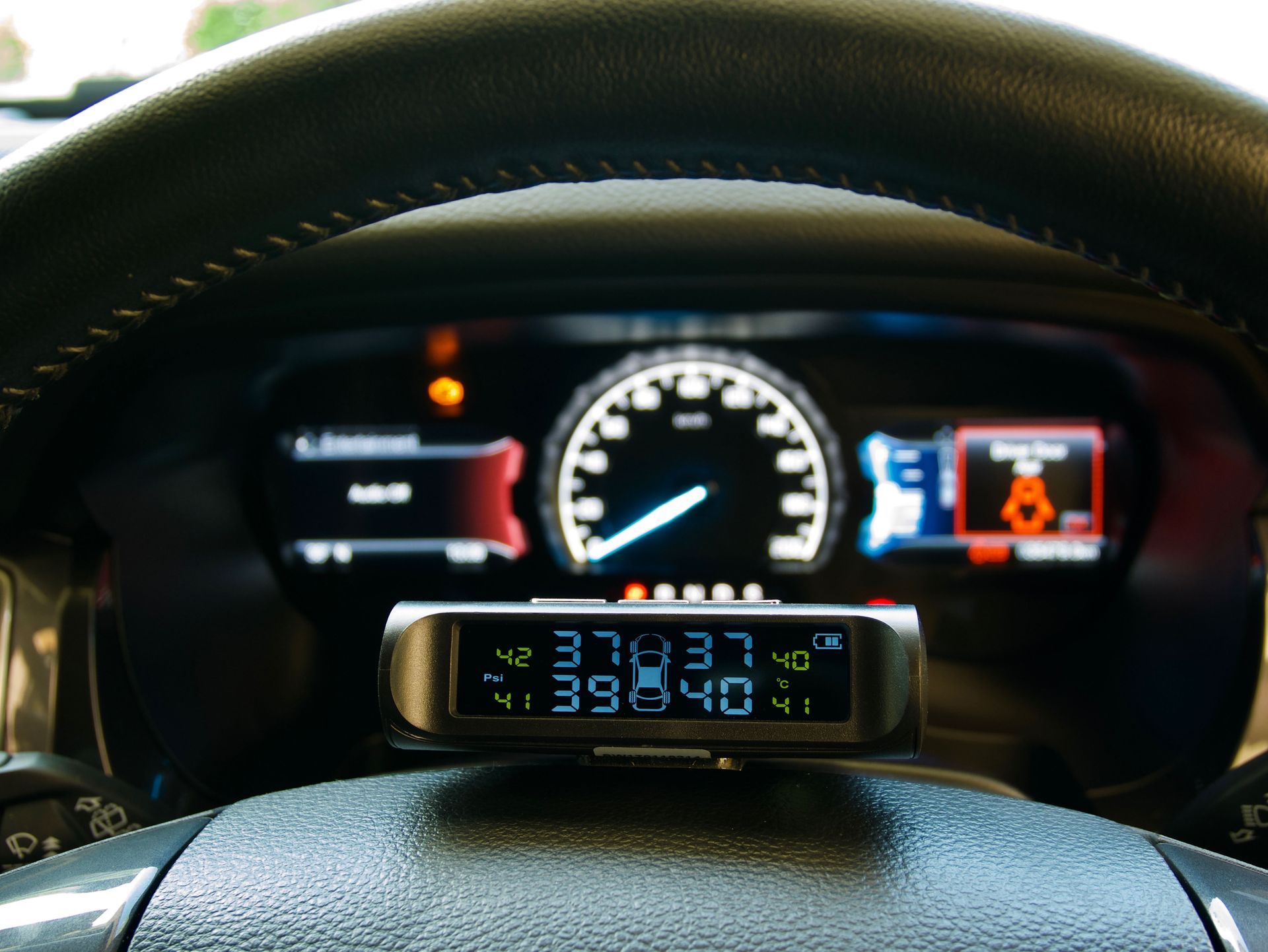 Dashboard with a tire pressure monitoring system displaying pressure readings; warning lights illuminated.