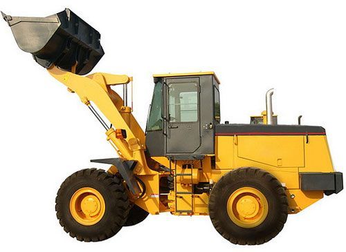 Yellow front-end loader with raised bucket, working on a construction site.