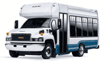 White and blue GMC shuttle bus with tinted windows, parked outside.