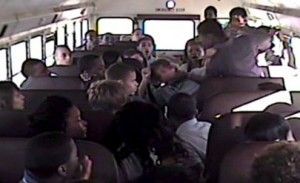 School bus interior with students. Some are yelling. Others are looking around.