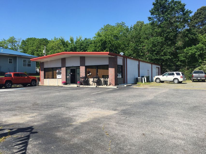 A building with a red roof and a lot of cars parked in front of it