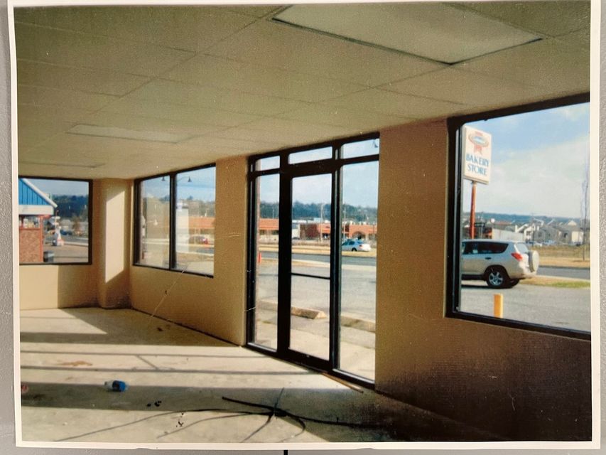 A picture of an empty building with a car parked in front of it