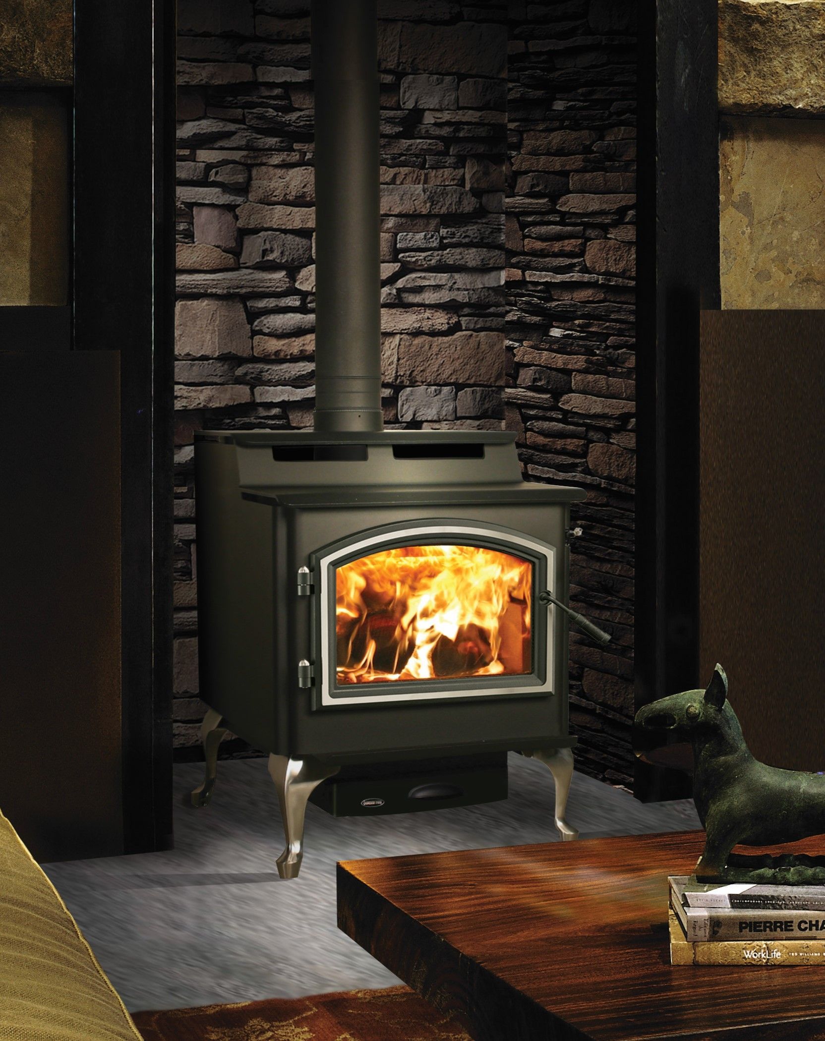 A wood stove in a living room with a stone wall