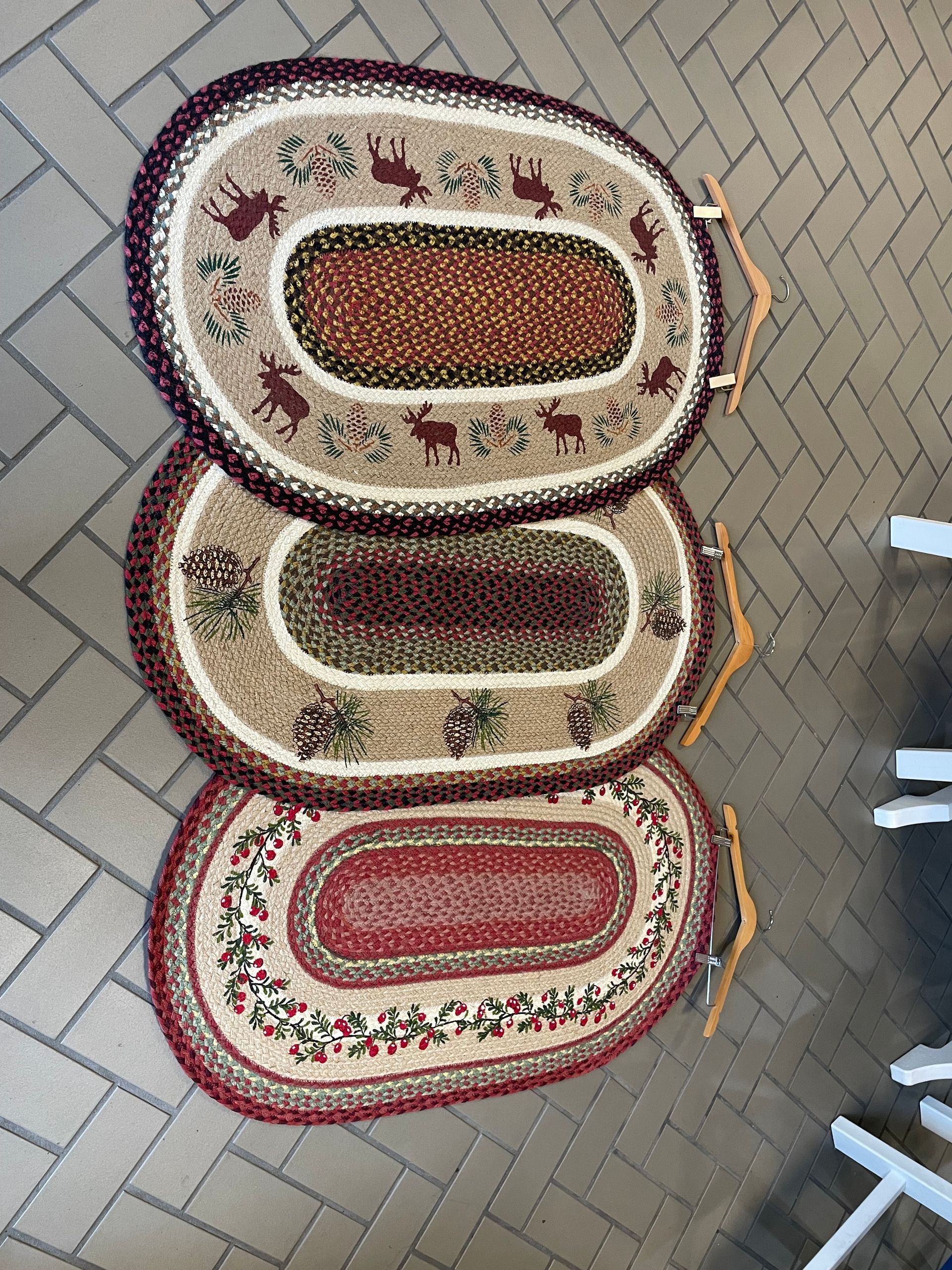 Three rugs are stacked on top of each other on a brick floor.