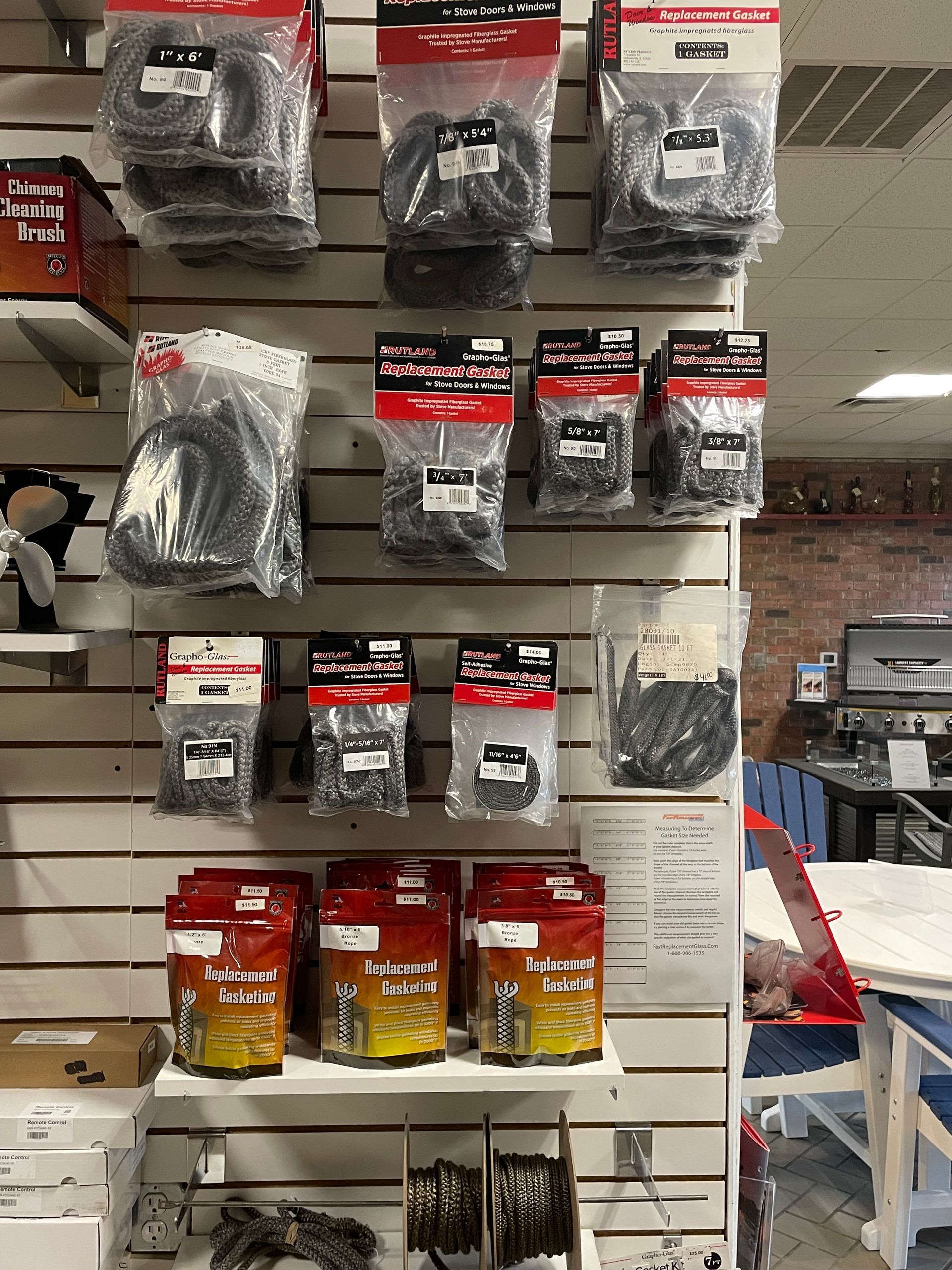 A wall with a bunch of bags of wires hanging on it.